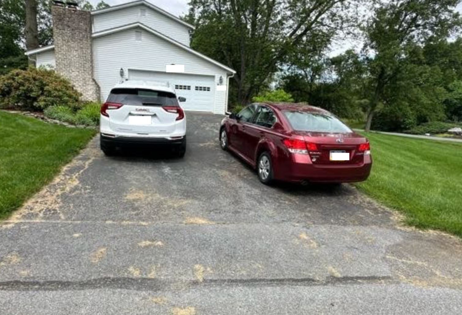 Damaged, old driveway with lots of cracks and low spot.